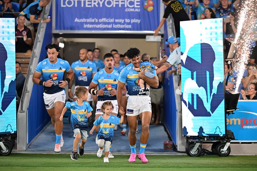 Brian Kelly runs out for a Titans game with his children.