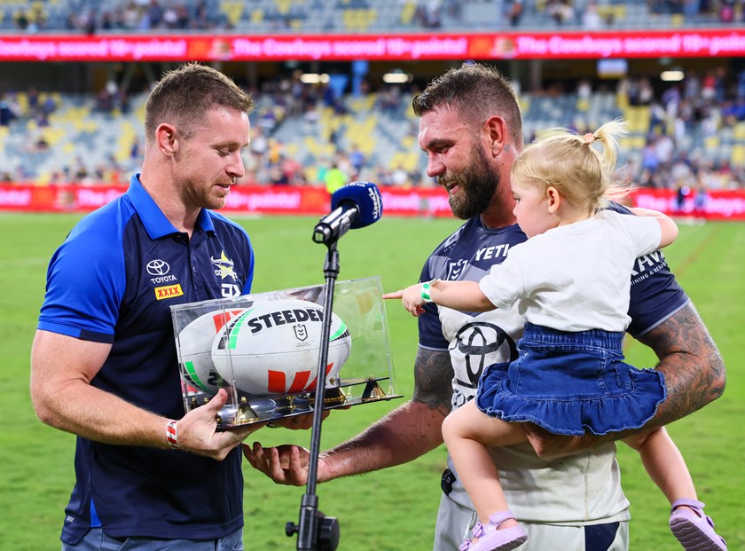 Michael Morgan presents Kyle Feldt with a match ball to commemorate scoring the most tries for the Cowboys. 